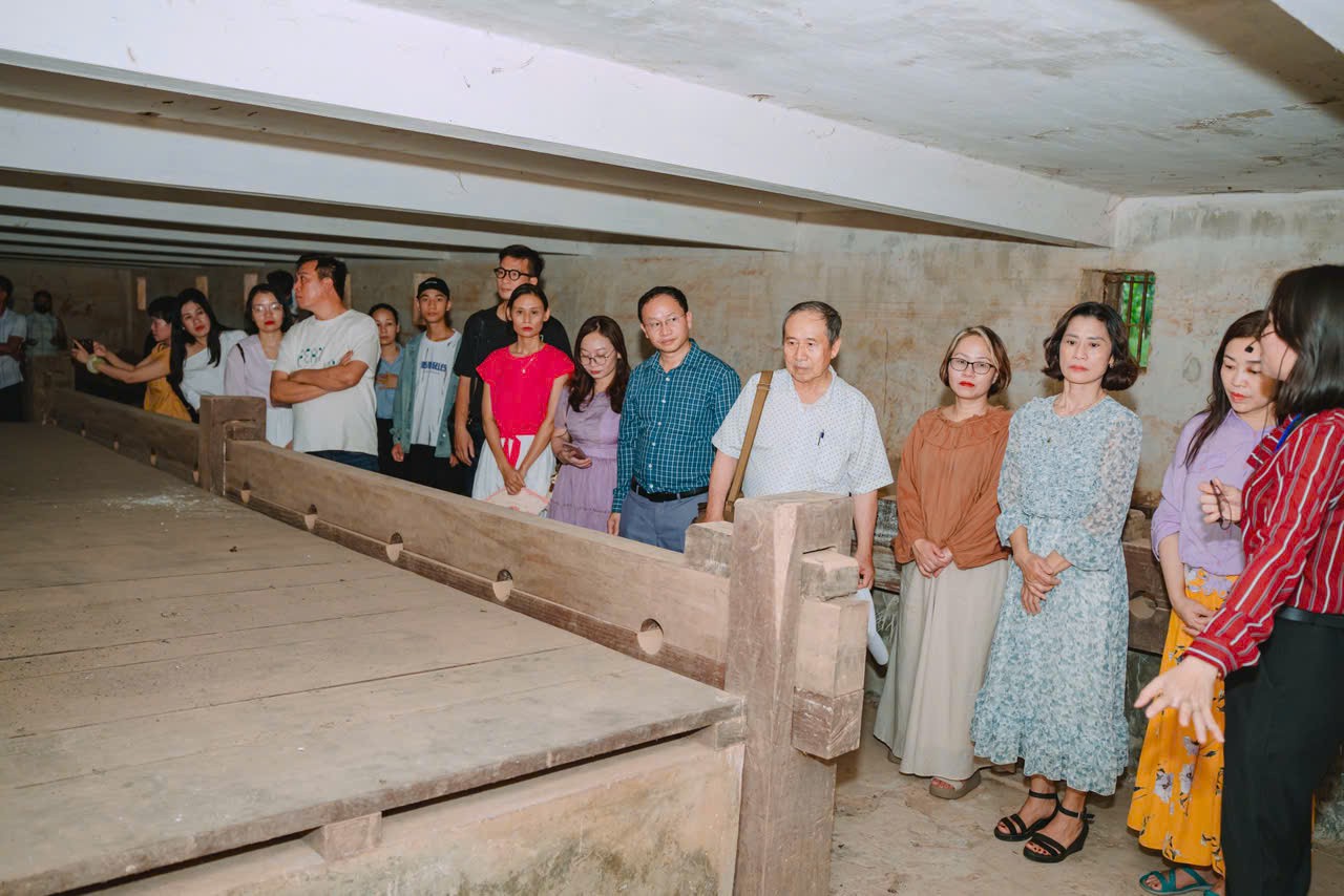 Các thành viên trong đoàn tham quan và nghe thuyết minh về các buồng giam trong hệ thống di tích nhà đày Lao Bảo. 